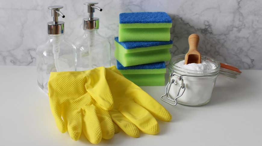Rękawiczki i gąbki do mycia oraz słoiczek z sodą oczyszczoną